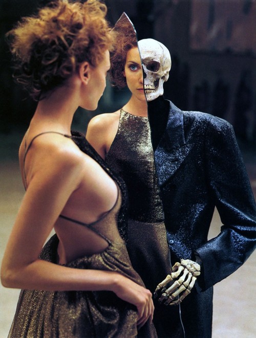 Une femme face à un miroir, auprès d’un squelette vêtu d’un costume.
